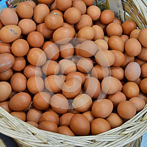 Yellow and brown fresh eggs in a wicker basket