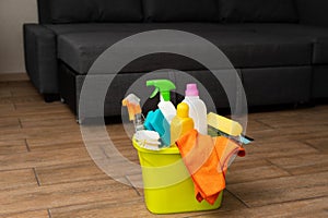 A yellow bucket with detergent in on the floor. The cleaning supplies are in bucket photo