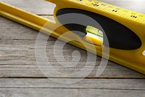 Yellow building level on the old wood table