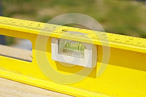 Yellow building level . working tool on wooden background