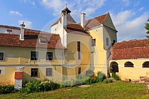 Yellow building is a part of the historical Church-fortress in the city of Harman. Transylvania. Romania