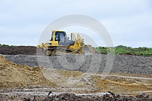 Yellow buldozer or excavator performs earthwork ground level layout