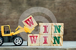 Yellow bulldozer hold letter block W to word win win