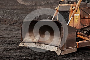 Yellow bulldozer near coal mine