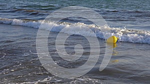 Yellow buoy floating in sea water slow motion. Sea buoy floating on water waves.