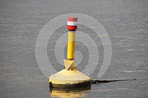 Yellow buoy in the river Hollandsche IJssel to characterize danger photo