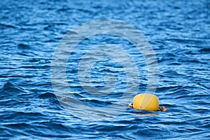 Yellow buoy on the sea waves background