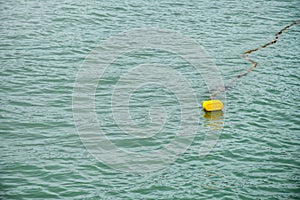 Yellow buoy on the water that is broken indicates the danger zone of the sea,On the background of the sea and waves, swim safely,