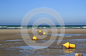 Yellow buoys on the beach at low tide