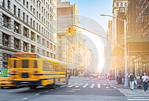 Yellow bus driving fast down Fifth Avenue in Manhattan New York City