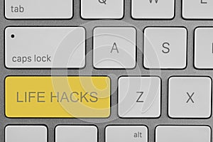 Yellow button with words Life Hacks on laptop, top view