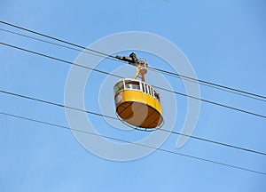 Yellow cabin ropeway on blue sky background