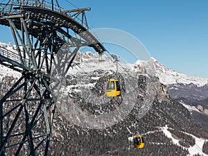 Yellow cable car ski lift going up on the mountain top