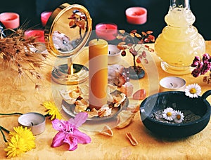 Yellow candle on Litha midsummer Sabbat Solstice celebration witch altar filled with flowers, rose petals, dandelions, crystals