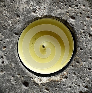 Yellow candle in porous rock hole. photo