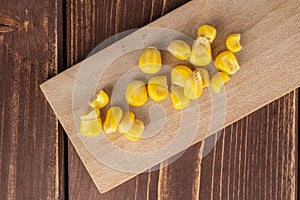 Yellow canned corn on brown wood