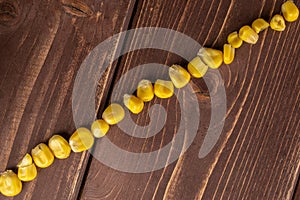 Yellow canned corn on brown wood