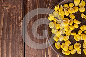 Yellow canned corn on brown wood