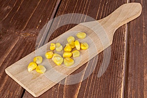 Yellow canned corn on brown wood