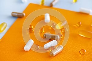 Yellow capsules of nutraceuticals in spoon. Pills and meds.