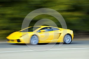 Yellow car driving fast on country road