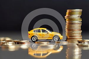 Yellow car model with coins, auto tax and financing, car insurance and car loans, savings money on car purchase