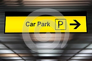 Yellow car park sign with arrow pointing to car parking zone