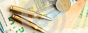 Yellow cartridges and shell casings on euro banknotes. Lot of bills of European union currency