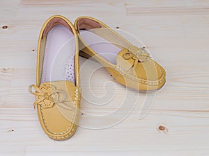 Yellow casual leather flat shoes on wooden background