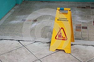 Yellow caution cleaning progress sign on the floor outdoors