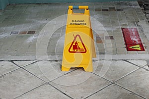 Yellow caution cleaning progress sign on the floor outdoors