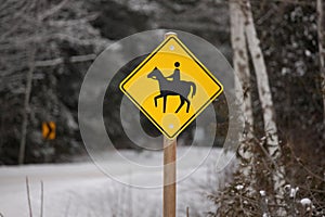 Yellow Caution Horse Riding Sign in a Rural Setting in Winter