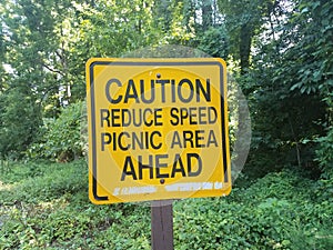 Yellow caution reduce speed picnic area head sign