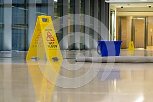 Yellow caution sign showing warning of slippery wet floor