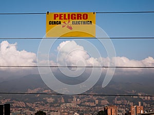 yellow caution sign in spanish hanging on an electric fence