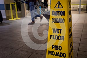 Yellow caution slippery wet floor sign .