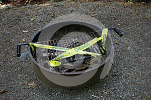 yellow caution tape on campground fire pit