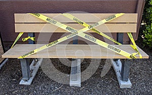 Yellow caution tape in english and spanish barring access to park beach at a park due to quarantine photo