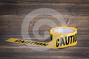 Yellow caution tape on a wooden background. Safety Barrier For Police Barricade, For Contractors