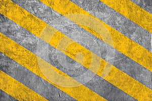Yellow caution warning lines on concrete floor grunge texture background.