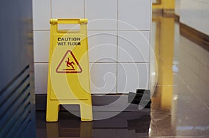 Yellow Caution wet floor cleaning in progress sign on wet floor