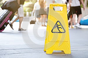 Yellow caution wet floor sign stands in airport