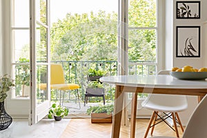 Yellow chair on the balcony of elegant kitchen interior, real photo