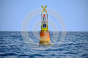 Yellow channel marker buoy floating in the sea - lighthouse nautical