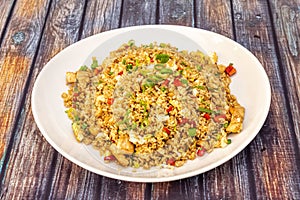 Yellow chaufa rice with chopped fried chicken, pieces of scrambled eggs, bell pepper and vegetables photo