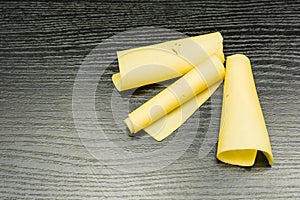 Yellow cheese rolled into rolls.