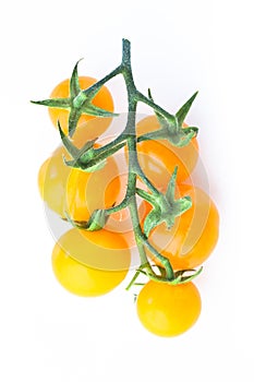 Yellow cherry tomatoes twig on white