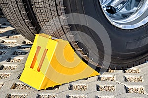 Yellow chock at the wheel of a parked truck