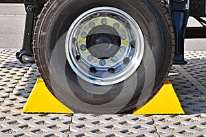 Yellow chocks at the wheel of a parked truck