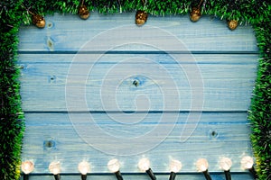 Yellow Christmas lights on wooden background.